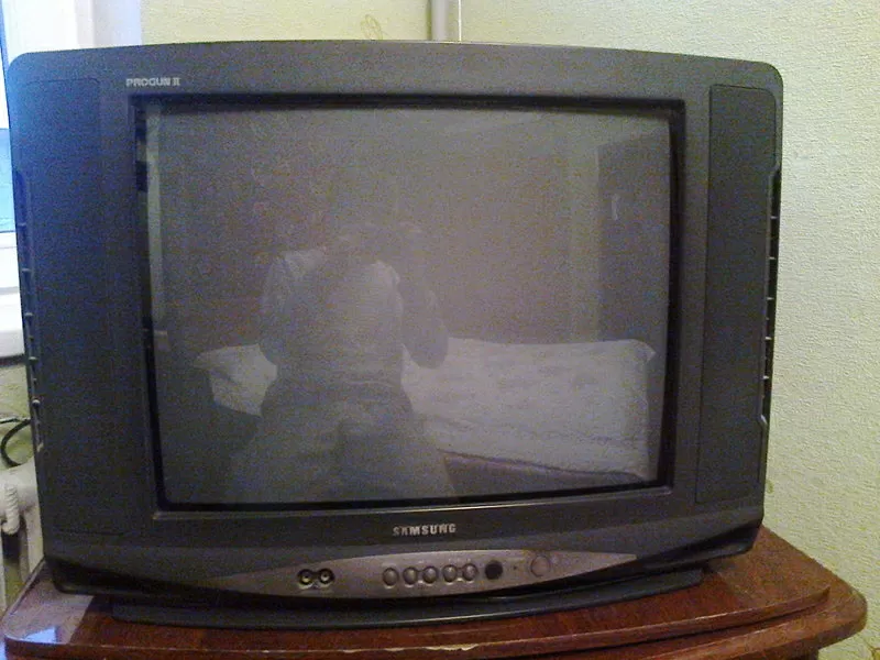 Телевизор и деревянный,  полированный столик под телевизор.